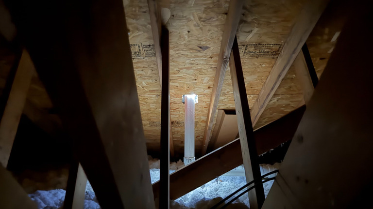 Attic framing and decking with a ventilation pipe